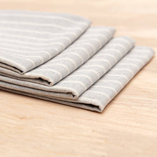 Load image into Gallery viewer, Stack of folded gray and white striped towels on a wooden surface
